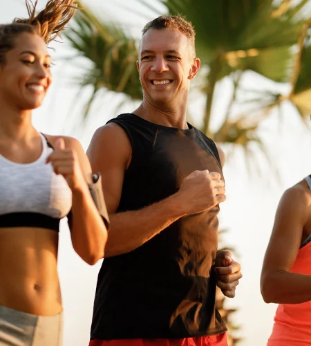 mid-adult-happy-sportsman-jogging-with-his-female-friends-nature